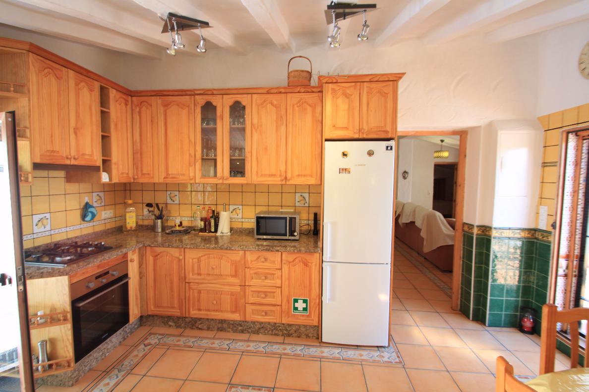 06 Küche mit Herd, Backofen, Kühleschrank mit Blick ins Wohnzimmer
